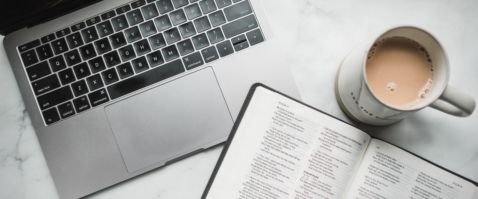 A laptop a bible and a cup of coffee